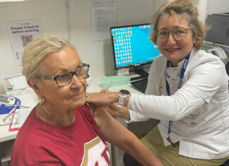 Pharmacist Sarah Parry-Okeden vaccinating a patient at Acton Health Pharmacy